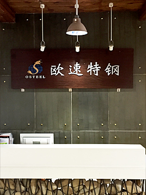 A plate of the Osteel company logo hanging on the wall